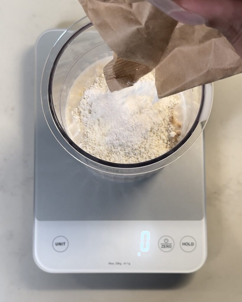 Pouring the sugar-free vanilla pudding mix into the pint