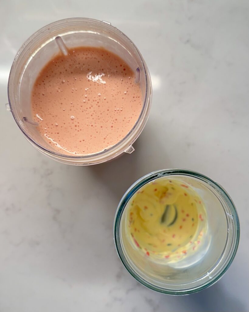 Strawberry Cake Batter Protein Shake next to Frosting Coated Cup